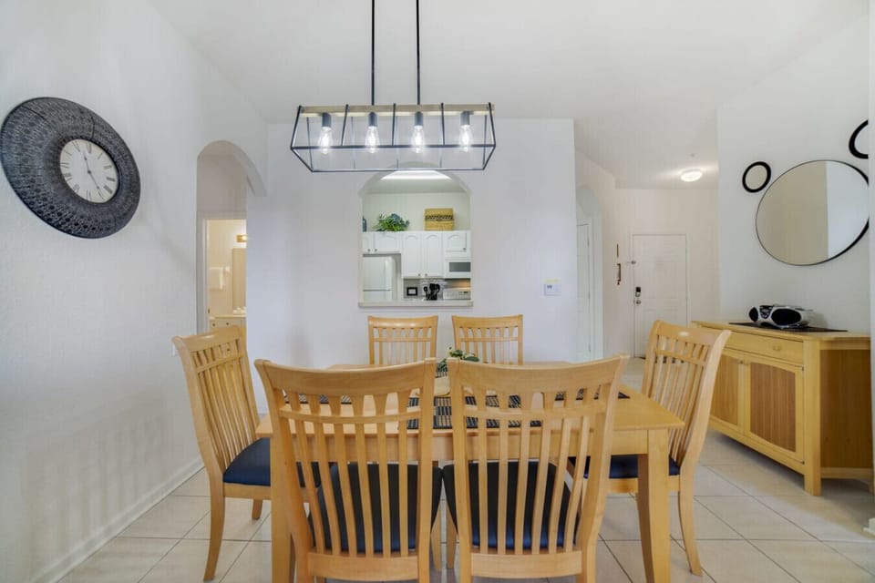 Dining area with seating for six and modern lighting.