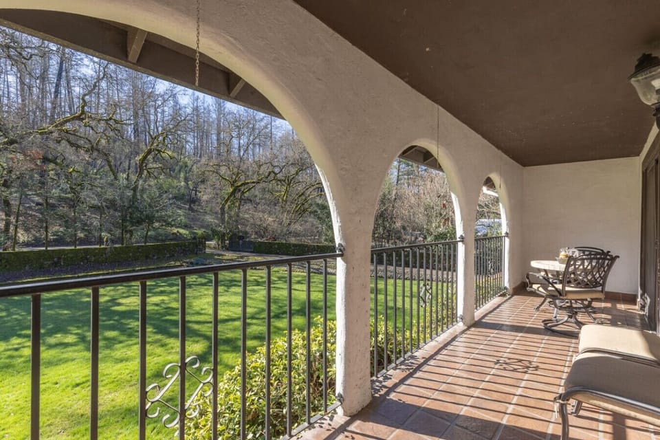🌿☀️ Morning coffee just tastes better with a view like this. Arched elegance, fresh air, and endless greenery—what more could you ask for? 🌿✨ #PeacefulRetreat #VerandaVibes #OutdoorLiving