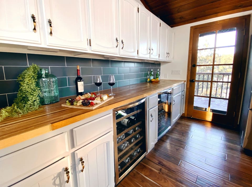 bar and two beverage fridges, door leads to the outdoor deck