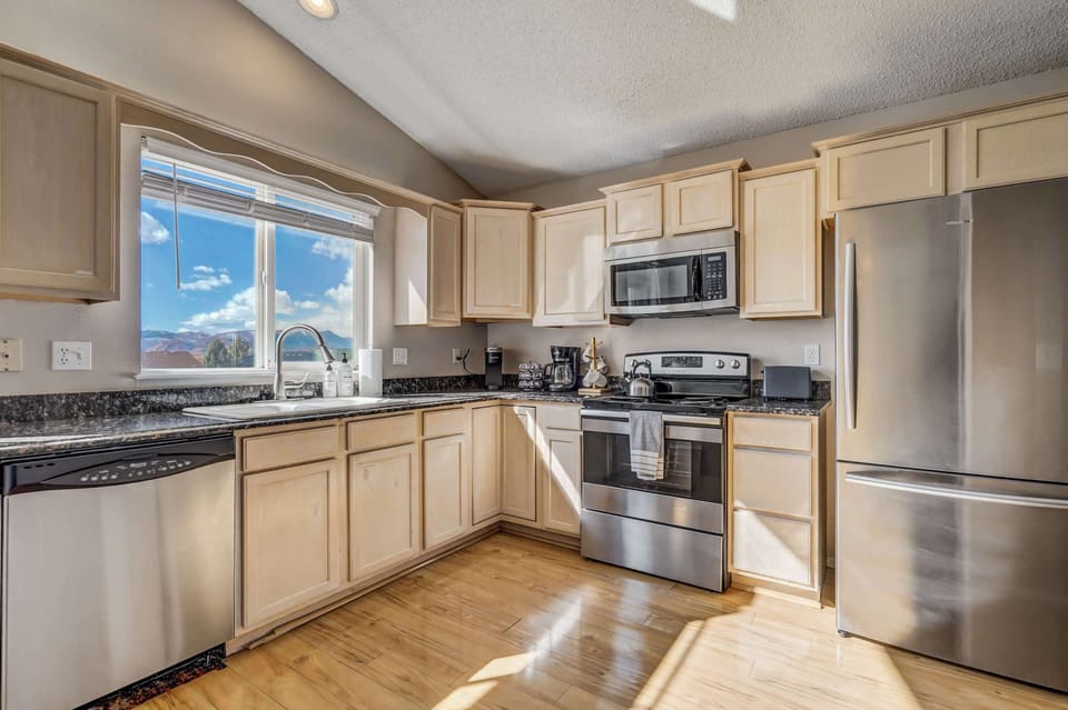 This fully equipped kitchen features stainless steel appliances, granite countertops, and a bright, open layout with scenic mountain views.

