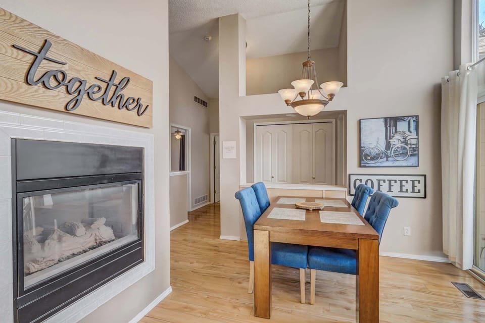 This cozy dining area is perfect for shared meals, featuring a warm double-sided fireplace and stylish decor that creates an inviting atmosphere.

