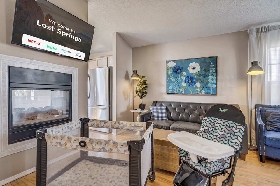 This family-friendly living space includes a cozy fireplace, comfortable seating, and thoughtful amenities like a pack-n-play and high chair for little ones.

