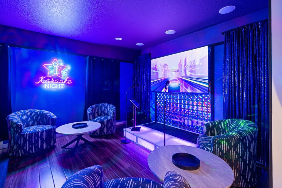 - Karaoke room with neon stage and sound system  
- Big screen and microphones for music entertainment  
- Lounge chairs and tables for family fun nights