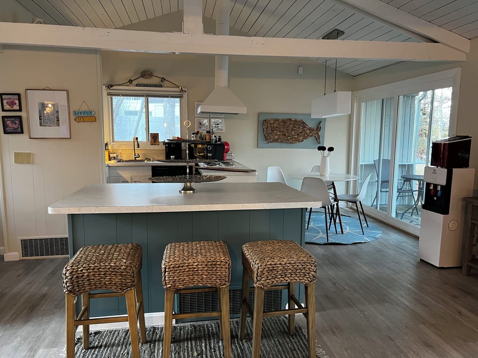 View of dining area and kitchen, large countertop and stools for gatherings