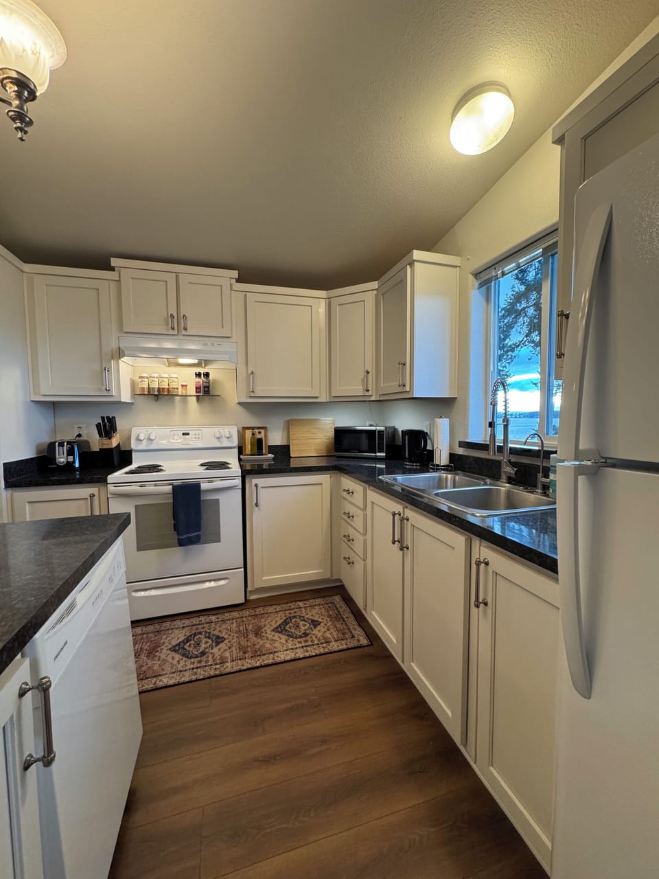 Kitchen with stove, oven, dishwasher, blender, toaster, kettle and coffee maker.