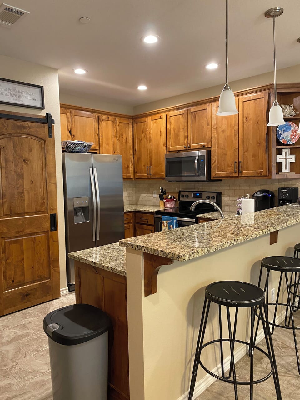 Fully stocked kitchen with Keurig and additional bar seating
