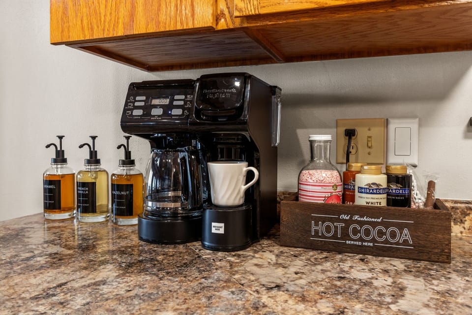 Start your morning at the fully stocked coffee bar, featuring a dual coffee maker and all the essentials for the perfect brew.