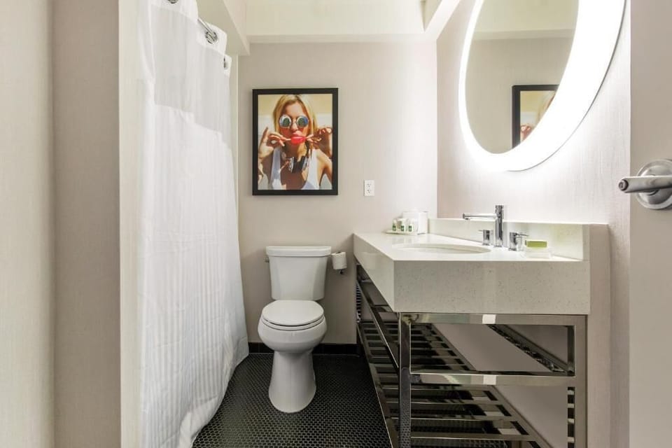Refresh effortlessly in a spotless bath with bright vanity lighting.