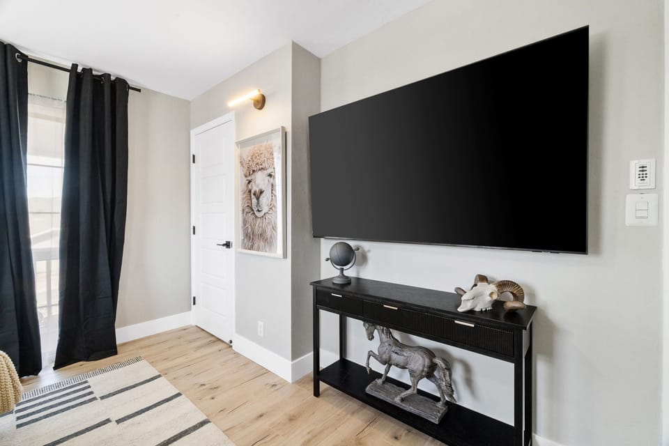 A massive 75-inch smart TV in the primary bedroom, perfect for unwinding with your favorite shows and movies in ultimate comfort.