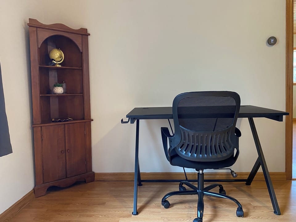 Office desk and chair in dining room area.
