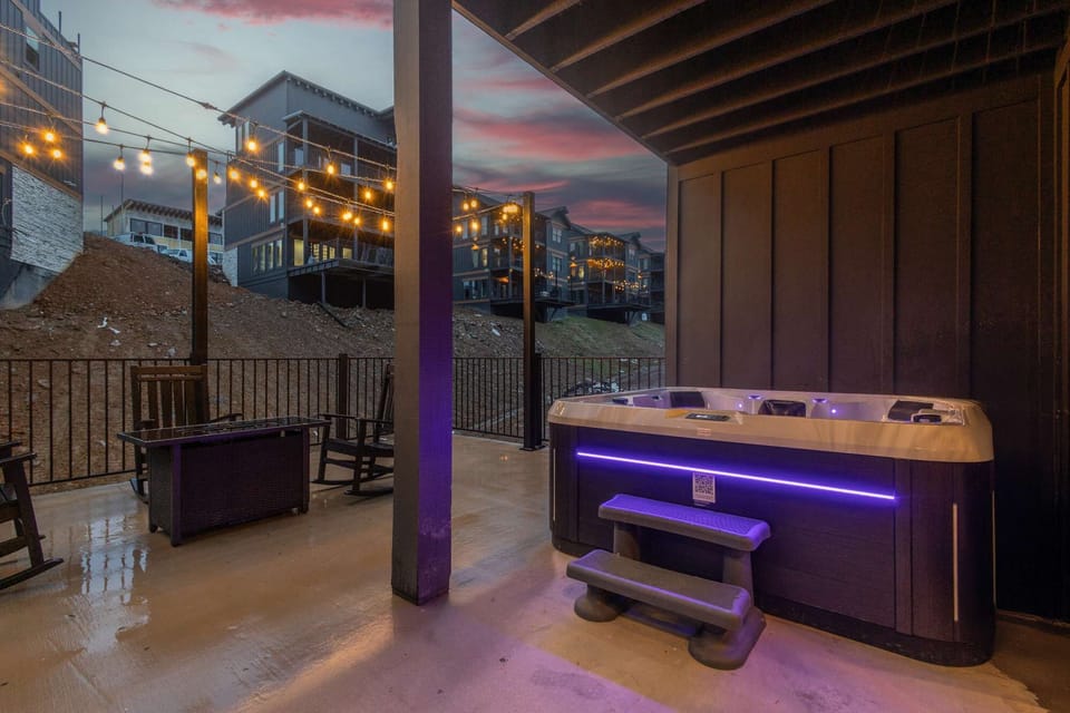 Nighttime hot tub view with glowing lights and cozy covered patio—your private spa experience.