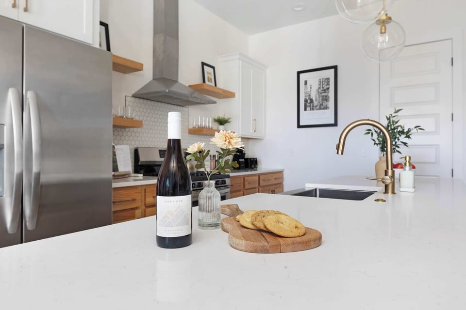 Modern kitchen with a spacious pantry and a large island with five barstools, ideal for cooking and casual dining