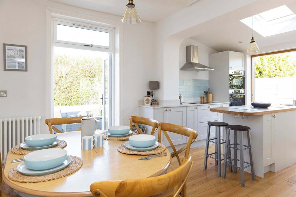 Enjoy family meals and gatherings in the bright and airy open-plan kitchen and dining area. This inviting space features a dining table with seating for six and seamless access to the outdoor patio.
