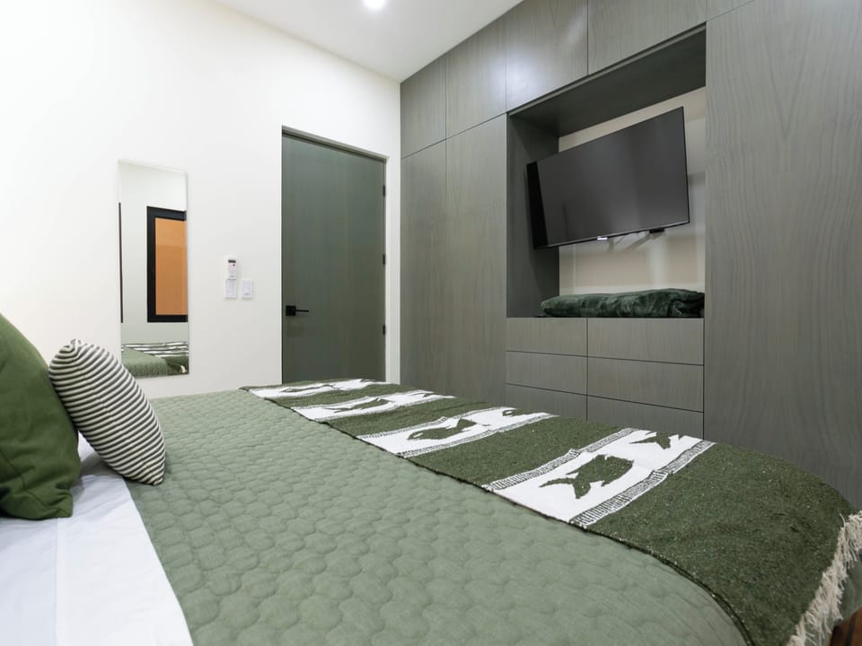 Cozy 3rd bedroom featuring a king-sized bed for ultimate comfort, a flat-screen TV for entertainment, and stylish decor to create a relaxing retreat. Perfect for guests seeking a peaceful space with all the amenities to feel at home.