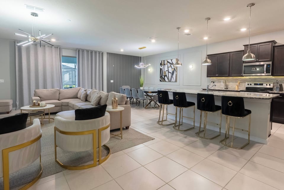 Step into a stylish living area where plush seating invites relaxation and conversation. The sleek kitchen features modern cabinetry and a spacious island perfect for casual dining, all bathed in warm, inviting light.