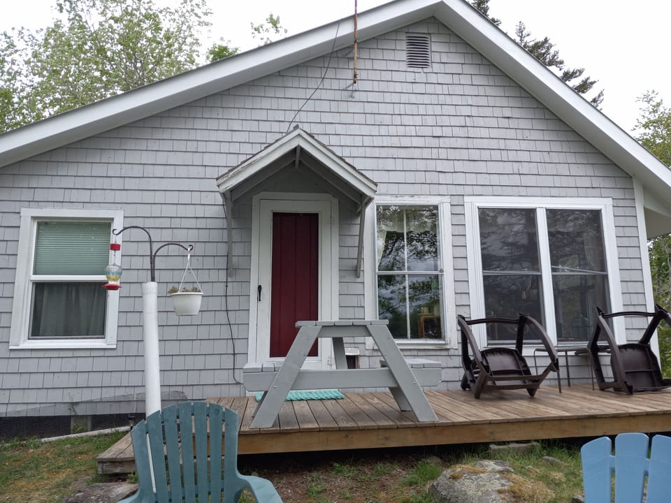 back door and deck with rockers and 2 person picnic table; hummingbird feeder