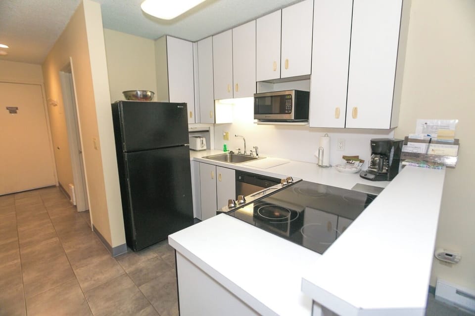 Brew morning coffee and prep snacks on bright countertops.