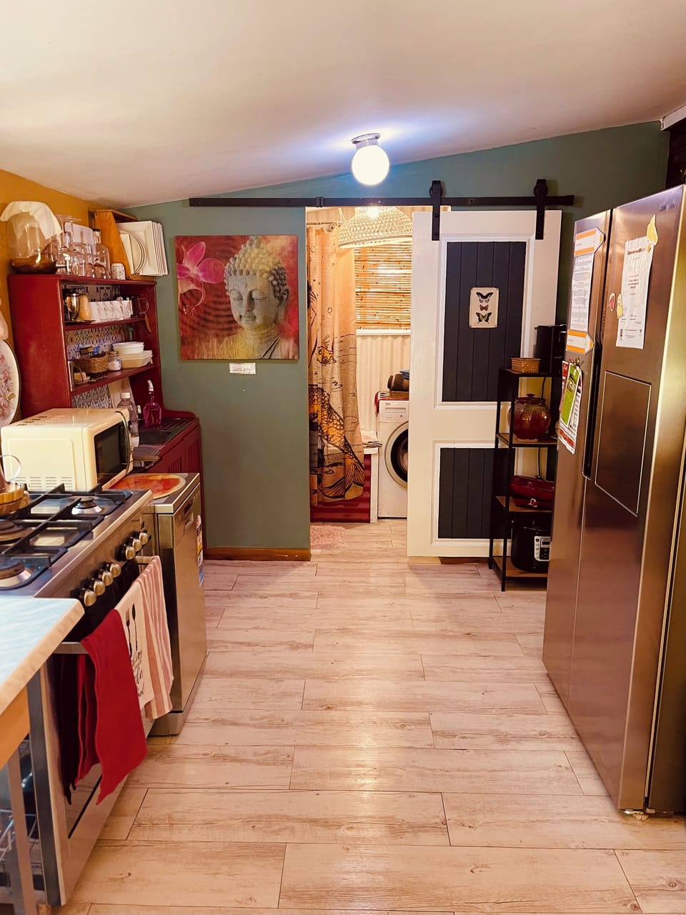 Spacious well decked out kitchen and bathroom with barn door at the end 