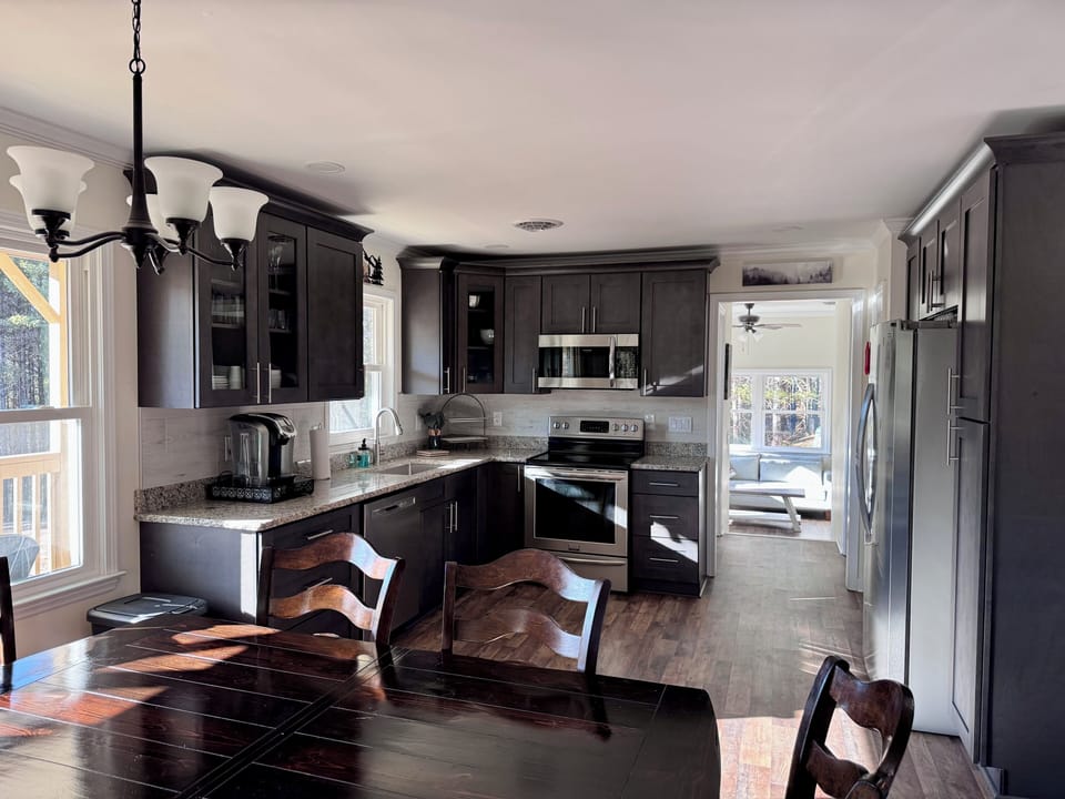 Dining table and kitchen with sunroom in the far back