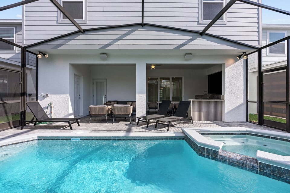 Step outside to your private oasis, where a sparkling pool glistens under the sun, framed by sleek loungers and a cozy dining area. The covered patio invites you to unwind while enjoying seamless indoor-outdoor living.