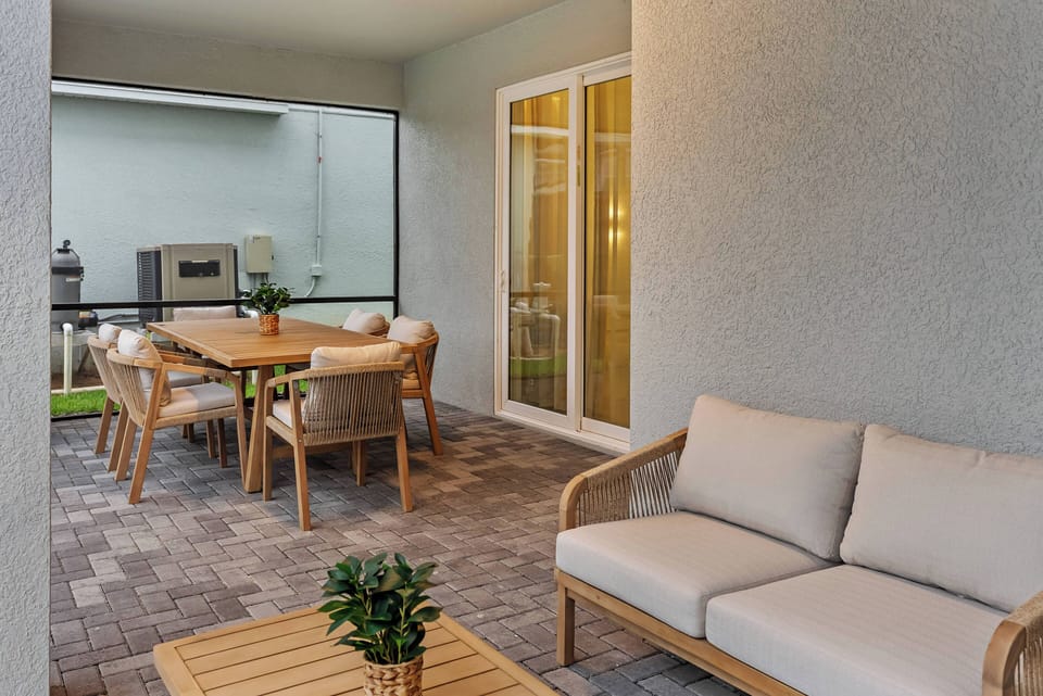 Enjoy our inviting outdoor space with modern wicker furniture and a wood dining set, perfect for relaxing and savoring al fresco meals, while soft ambient lighting creates a lovely atmosphere for evening gatherings.