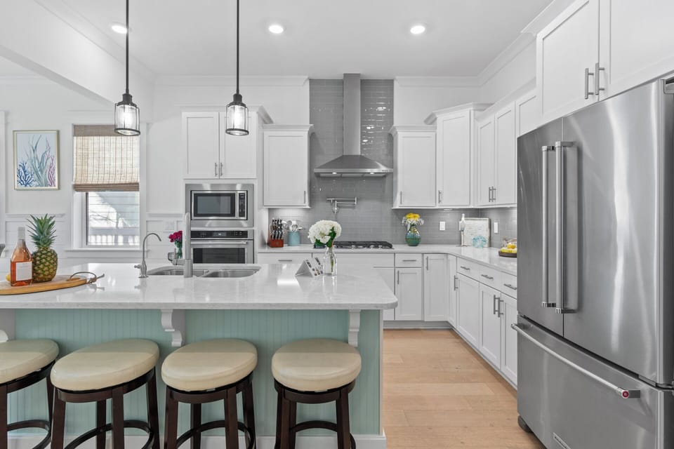 Kitchen features an island with barstool seating.