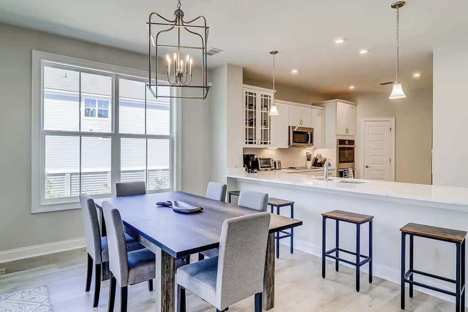 Adjacent to the kitchen, the dining space features a dark wood table.
