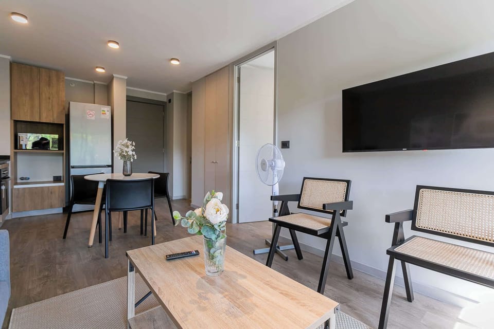 Relax in this modern living room with stylish seating, a large TV, and a cozy dining area perfect for intimate meals.