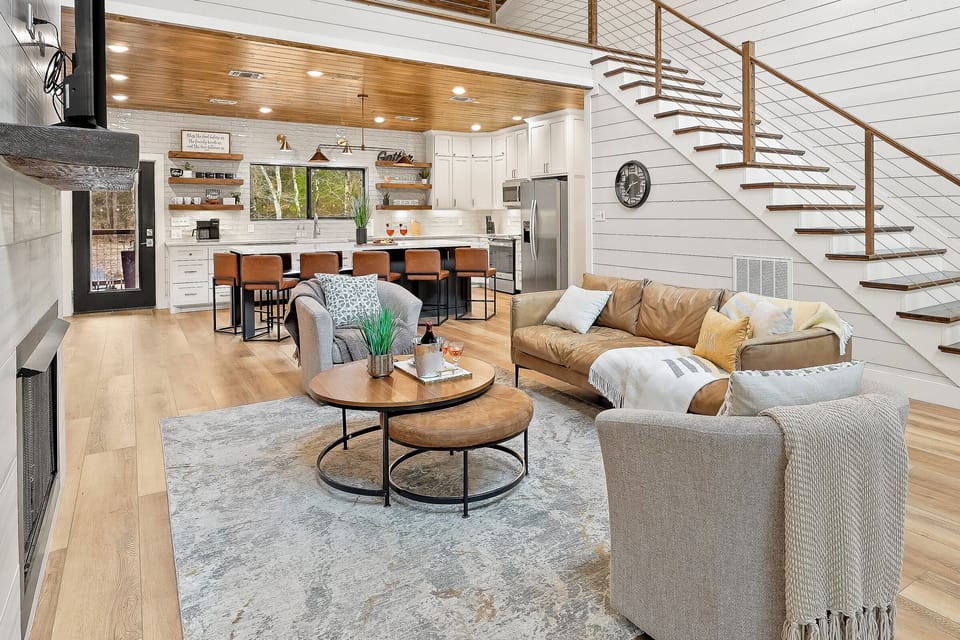 Step into this inviting living space, where the first floor welcomes you with comfort and style. A beautiful staircase leads to the cozy loft area above, featuring arcade games and extra beds—ideal for fun adventures and a little extra space for everyone.