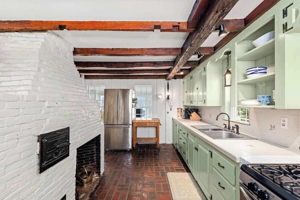 Exposed wooden beams, brick floors, and brand new stainless steel appliances