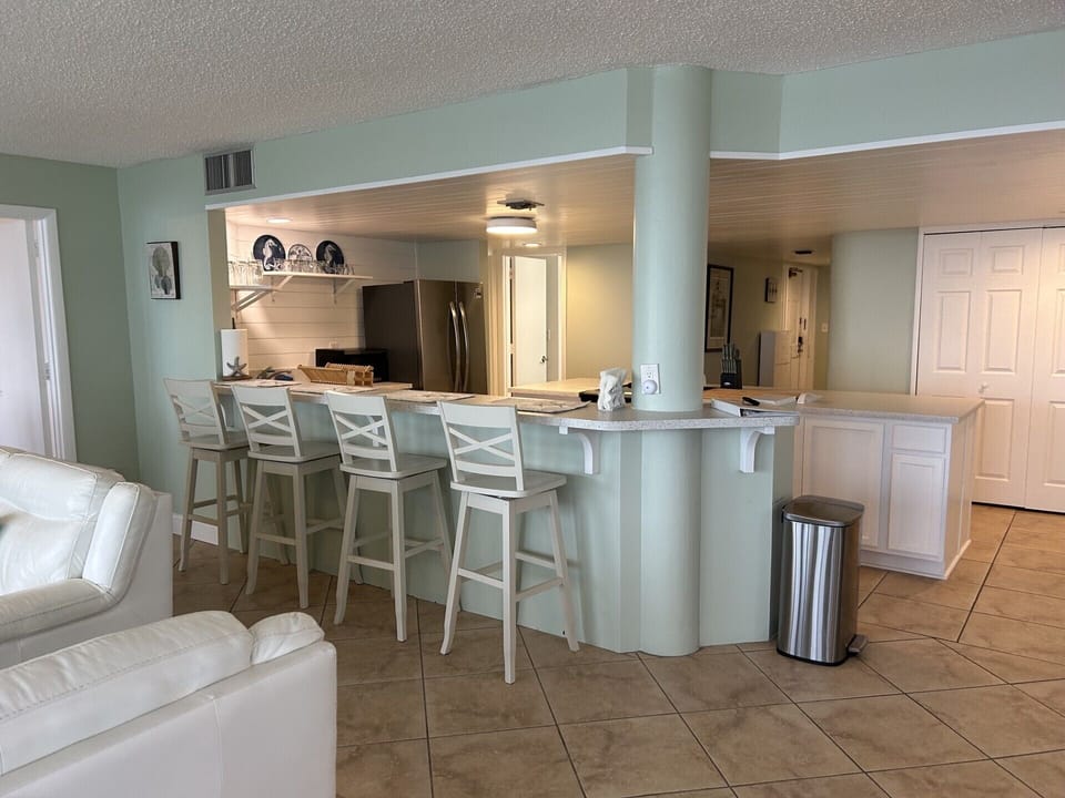 Kitchen with new appliances, countertop, bar stools and newly painted. 