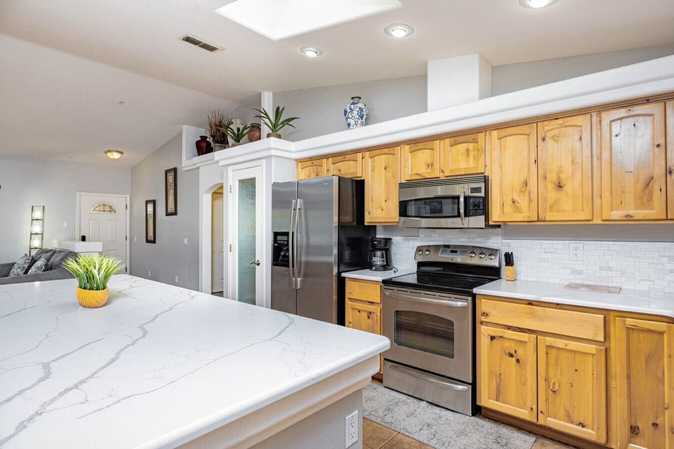 Fully stocked kitchen with drip coffee maker, cookware, and utensils