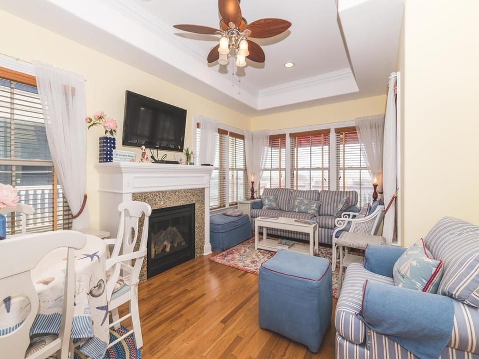 Another angle showing the bright and open living space featuring abundant natural light and a wall-mounted TV.