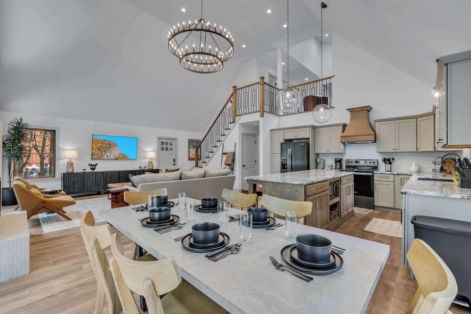 Elegant Dining & Entertaining Space – A spacious dining table set for a feast, perfectly positioned under a striking chandelier for a luxurious touch.