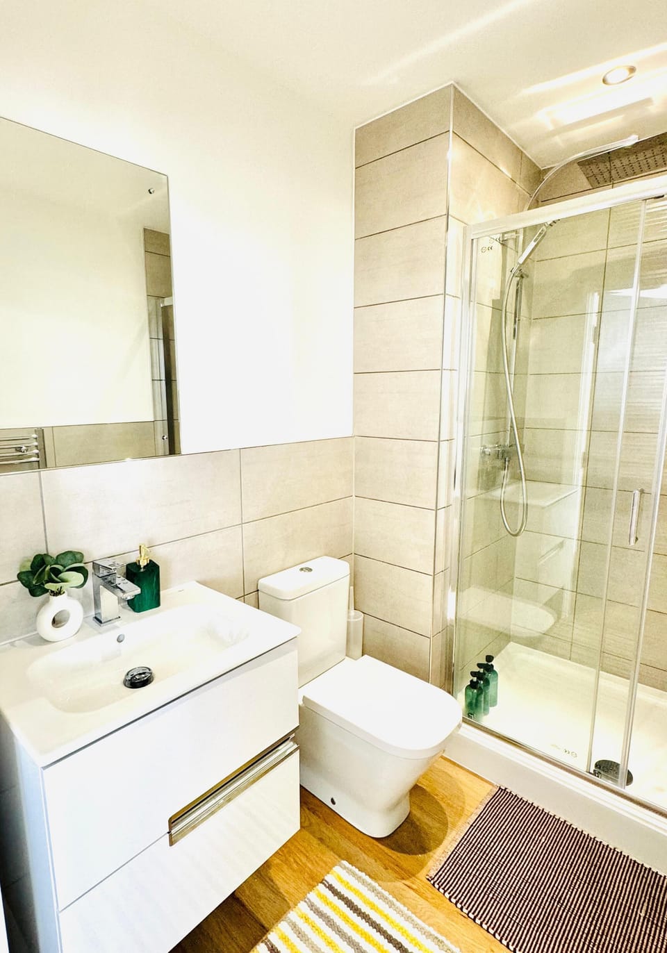 Clean and bright bathroom with a full-size bath and overhead shower, fresh towels provided for every guest