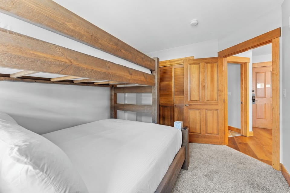 Guest bedroom featuring a twin-over-queen bunk bed and flat-screen TV, perfect for the kids!