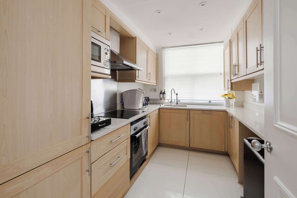 A fully equipped kitchen featuring a fridge freezer, Nespresso machine with pods, and a full selection of champagne, wine and martini glasses, washing machine, dryer and dishwasher for ultimate convenience.