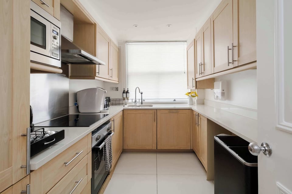 A fully equipped kitchen featuring a fridge freezer, Nespresso machine with pods, and a full selection of champagne, wine and martini glasses, washing machine, dryer and dishwasher for ultimate convenience.