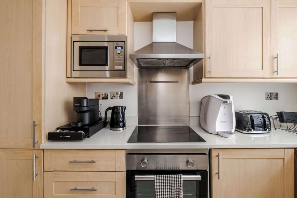 A fully equipped kitchen featuring a fridge freezer, Nespresso machine with pods, and a full selection of champagne, wine and martini glasses, washing machine, dryer and dishwasher for ultimate convenience.