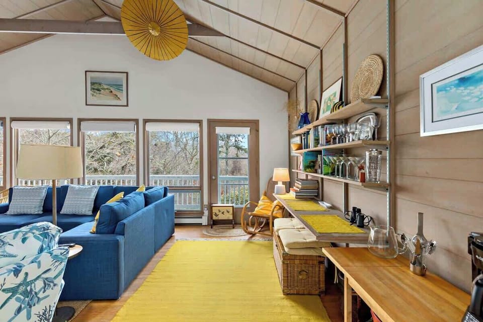 This bright space boasts a wall of windows and direct access to the front deck