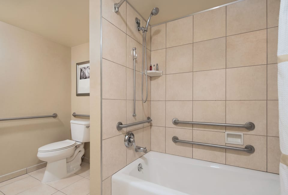 Soak or shower comfortably with easy-access rails and clean tile.