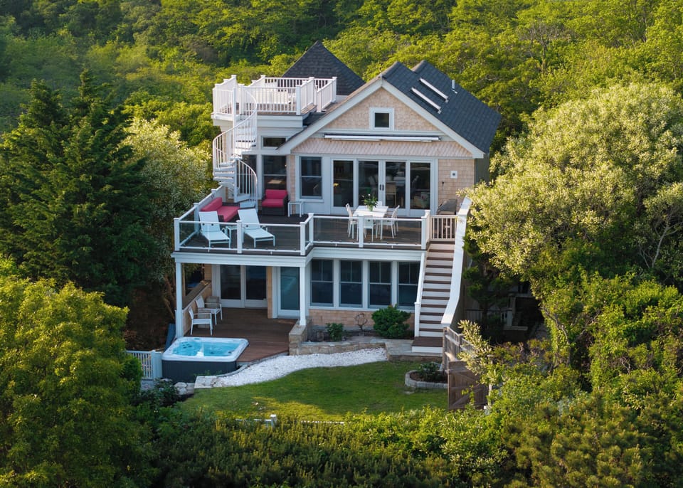 Exterior view of the home, can see rooftop balcony, back porch, and hot tub