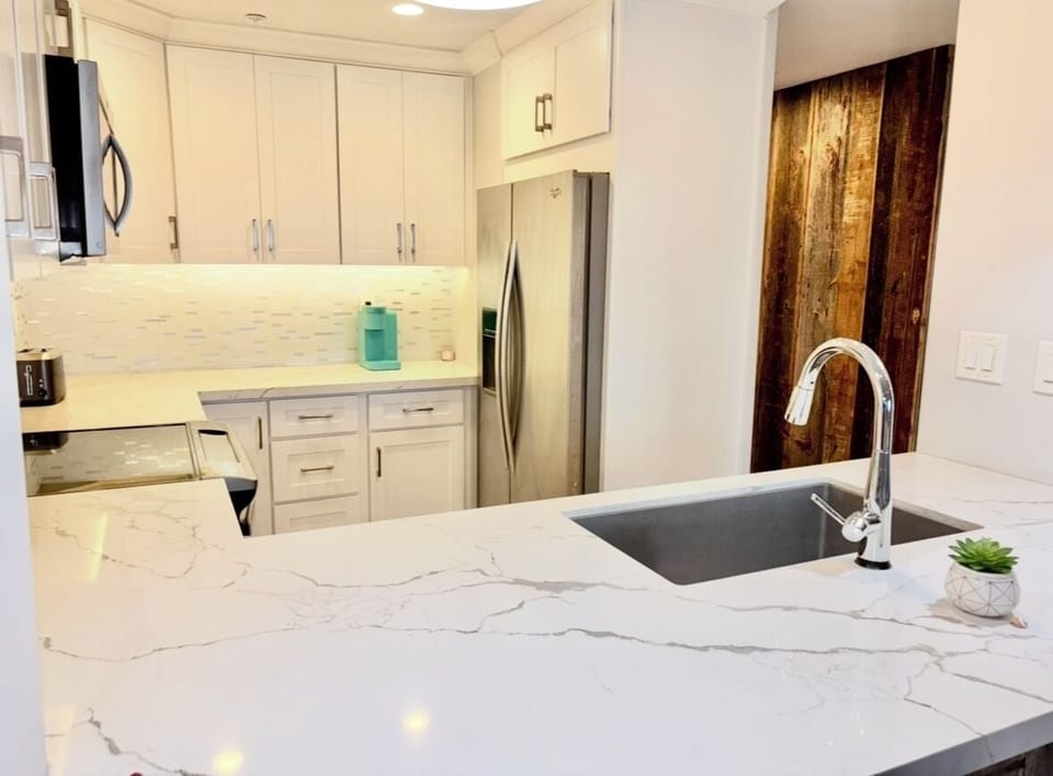 Beautiful white and grey marble counters and backsplash, soft close doors