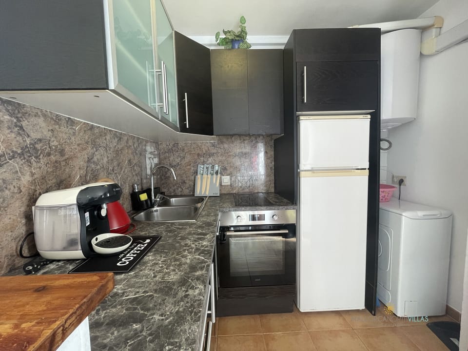 Kitchen with fridge, oven, sink and washing machine