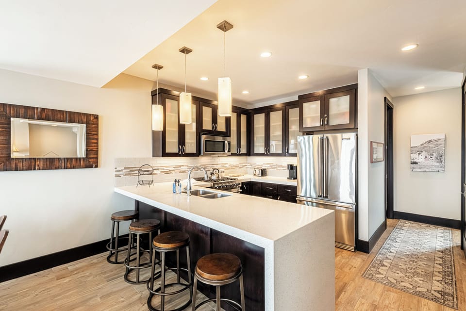 Fully Equipped Kitchen with stainless steel appliances, counter with 4 bar stools