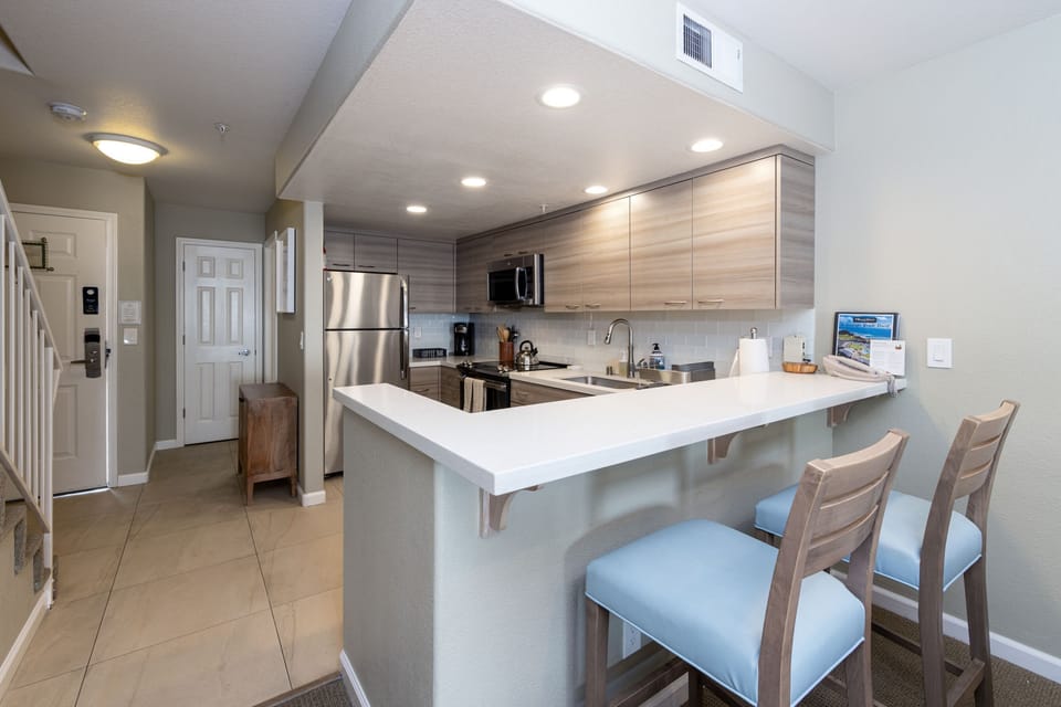 Bar Seating to Kitchen. Downstairs Half Bathroom behind Kitchen