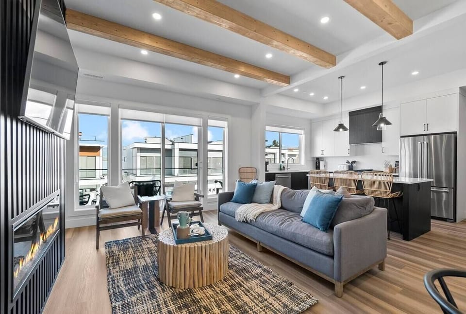 Living room with a sofa and chairs, offering a comfortable space to relax while enjoying a view of the outdoors.