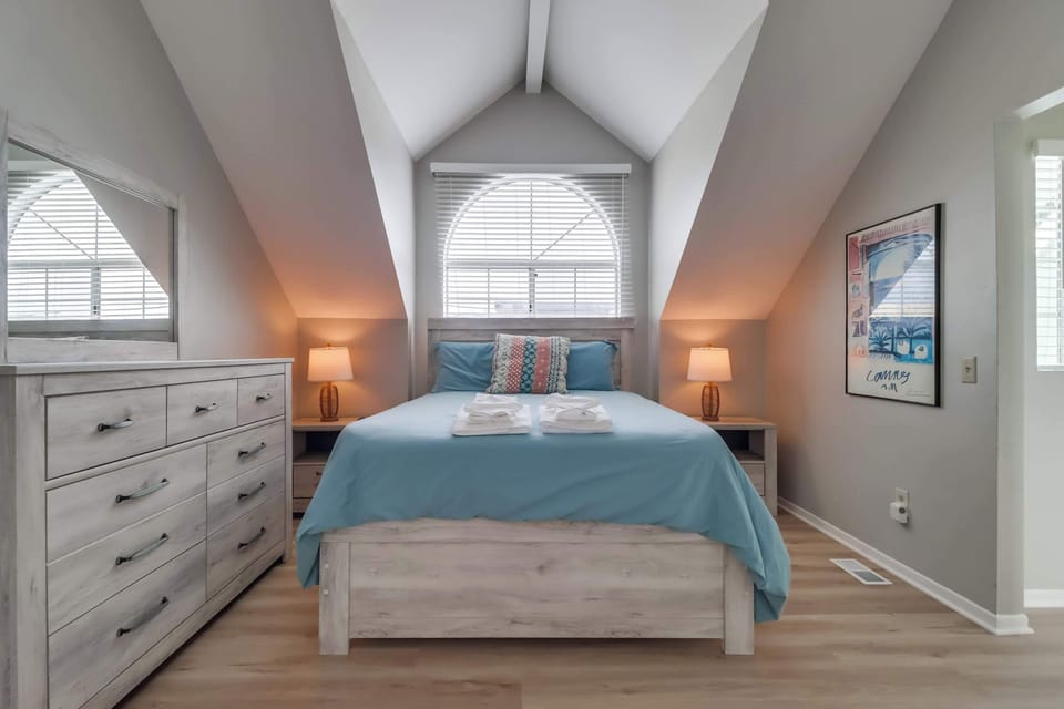 Top floor bedroom with queen bed, central A/C, chest of drawers and mirror, closet.