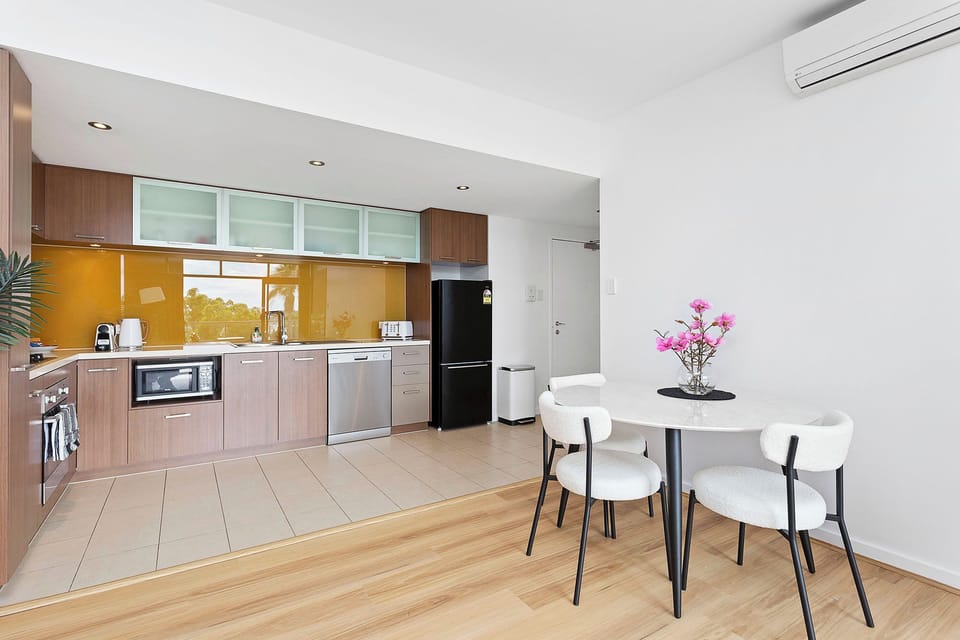 Enjoy cooking and dining in this modern kitchen, featuring sleek cabinetry and a bright dining space.