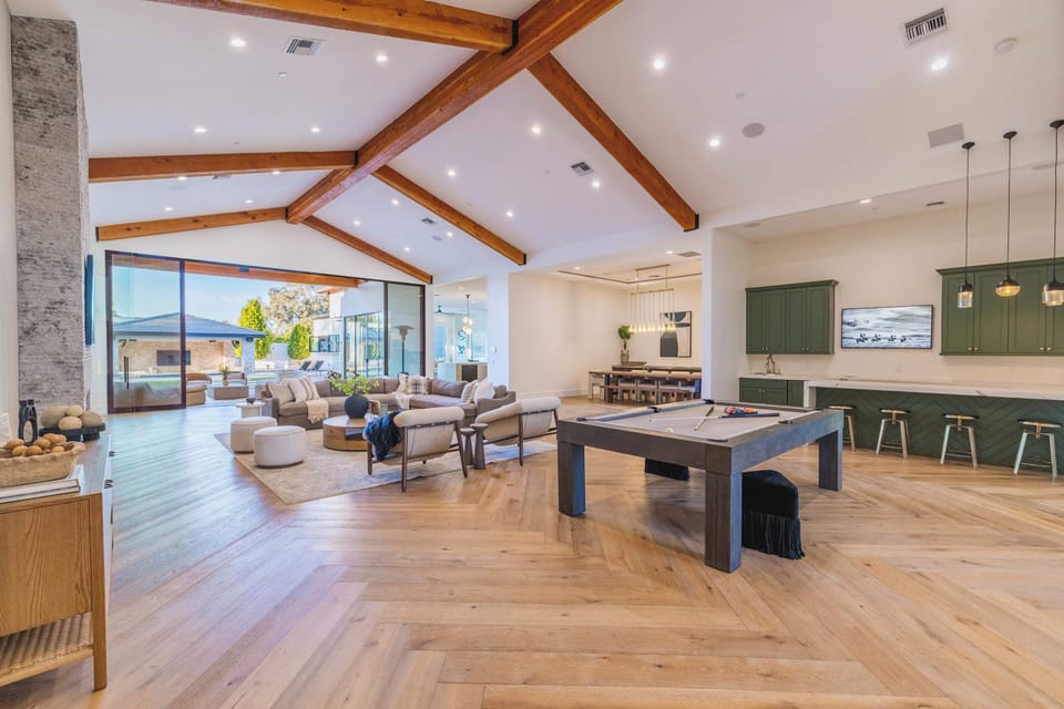 Open Living Space – Vaulted ceilings, exposed beams, pool table, and seamless indoor-outdoor flow.
